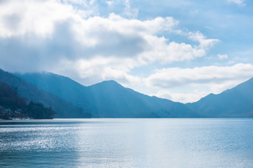 Obraz premium beautiful day landscape of lake Chuzenji with trees, mountains and sun beams near Nikko, Japan, travel background