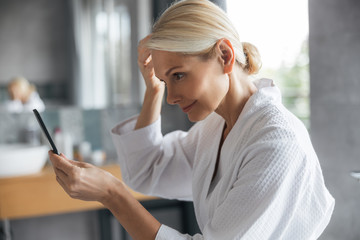 Attentive young female person staring at her hair