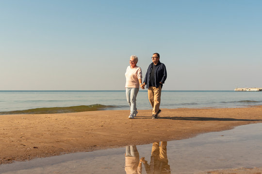 Loving elderly couple walking on the seaside.  Happy retirement concept