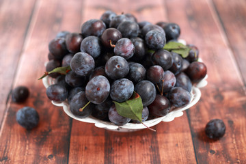 blue plums from his garden on a wooden table