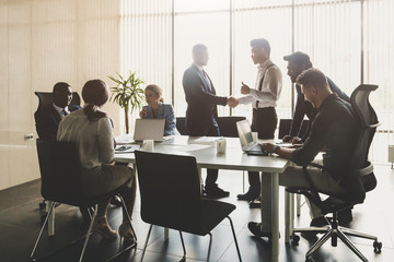 A team of young businessmen working and communicating together in an office. Corporate businessteam and manager in a meeting