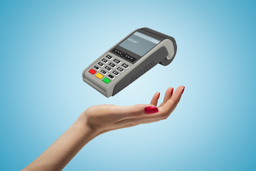 Female hand with PIN pad on blue background