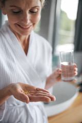 Portrait of charming woman that looking at pills