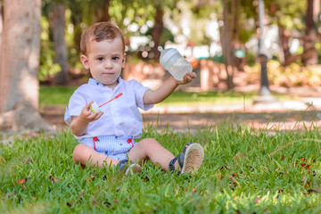 little boy with white shirt and blue pants with a bottle of water