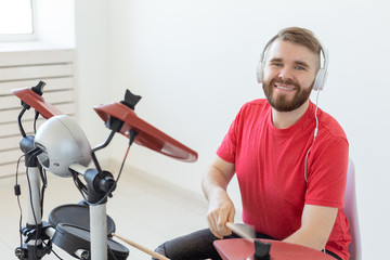 People, music and hobby concept - Man in his spare time playing the electronic drum set