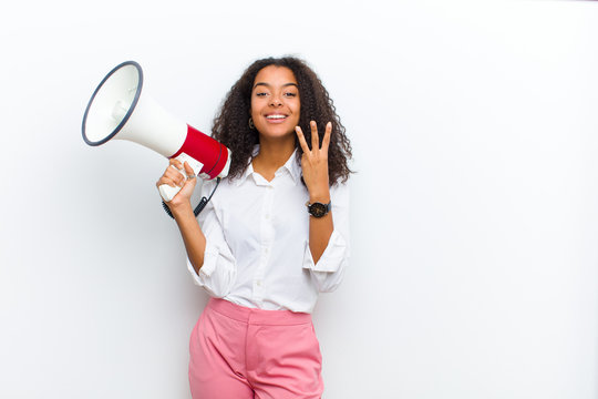 Young Pretty Black Woman With A Megaphone Against White Wall