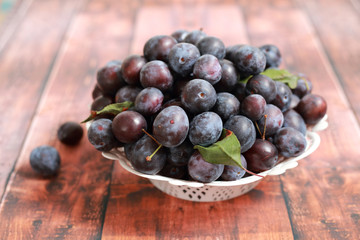 Fototapeta premium blue plums from his garden on a wooden table