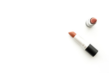Two red tone lipsticks are on top of white table. Top view with copy space, flat lay.