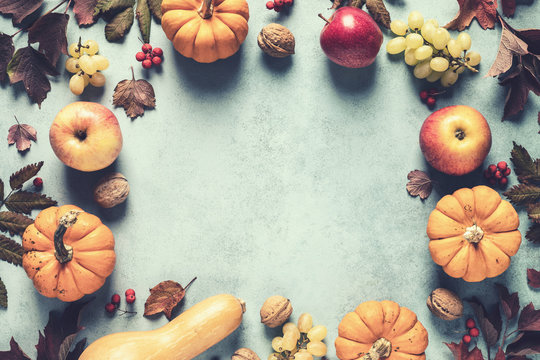 autumn background of fall leaves and pumpkins and variety harvest fruits and blank space for a text, may used for thanksgiving or halloween or another autumn holidays