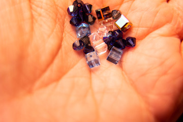 Tiny crystals being held in woman's hand, miniature crystal chips. Macro photo in natural...