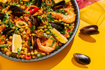 Spanish paella with seafood on the background of the Spanish flag