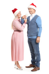 Obraz premium Portrait of happy mature couple in Santa Claus hats and with glasses of champagne on white background