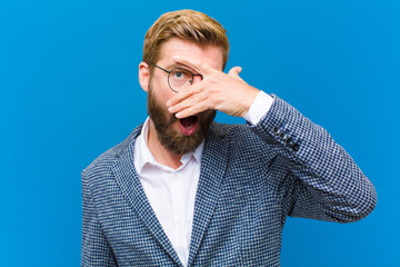 looking shocked, scared or terrified, covering face with hand and peeking between fingers
