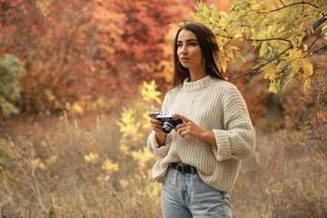 Woman photographer take a photo walking in the autumn forest