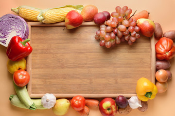 Board with many healthy vegetables and fruits on color background