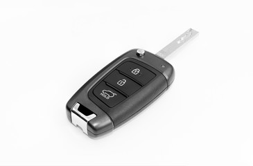 Typical car key isolated on white background. The automobile ignition key with built-in electronic brelok. Device with buttons: lock, unlock doors and trunk opening.
