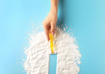 Female hand with razor and shaving foam on color background