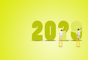 New Year Concept : Painter standing on wooden ladder and painting words to change 2019 to 2020 for new year decoration.