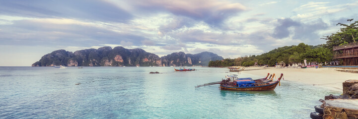 Tropical sandy beach with wooden boats on foreground - Phi-Phi island Long beach panorama, Krabi Province, Thailand