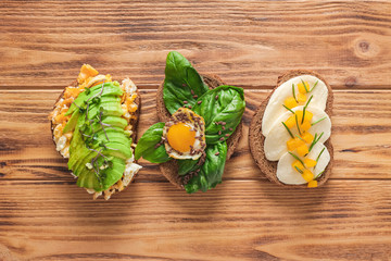Different tasty sandwiches on wooden table