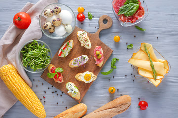 Board with different tasty sandwiches on wooden table