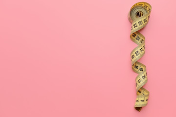 Measuring tape on color background