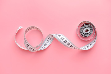 Measuring tape on color background