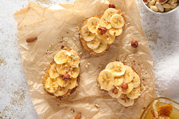 Tasty sweet sandwiches with banana on parchment