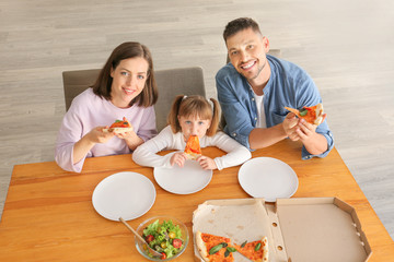 Happy family eating pizza at home