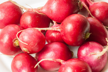 Red radish lies on a plate on the table