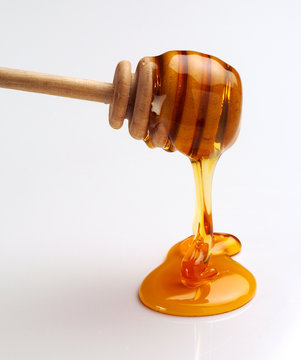 Flowing Honey Pour from Twizzle Stick against white