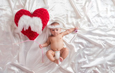 cute asian four-month baby in cupid dress smiling