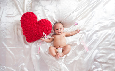 cute asian four-month baby in cupid dress smiling