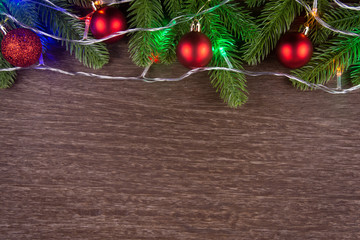 Christmas decorations with branches of fir tree and christmas lights, ball on wood on wooden background. copy space
