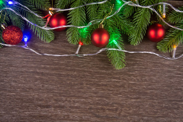 Christmas decorations with branches of fir tree and christmas lights, ball on wood on wooden background. copy space