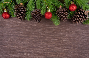 Christmas decorations with branches of fir tree, christmas ball and Pine cones on wooden background. copy space