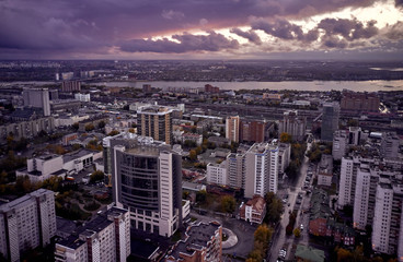 aerial cityscape. evening over the capital of Siberia - Novosibirsk. heavy dark clouds over the city and fall foliage on trees among urban high-rise buildings