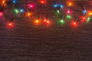 Christmas lights on dark wooden background. Merry christmas and happy new year with copy space for a text.