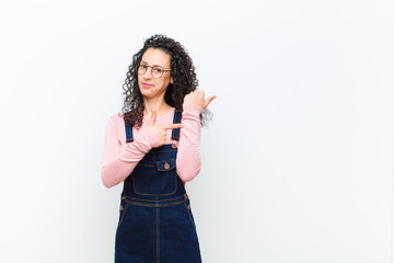 young pretty woman looking impatient and angry, pointing at watch, asking for punctuality, wants to...