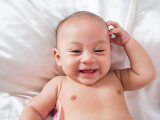 cute asian four-month baby in cupid dress smiling