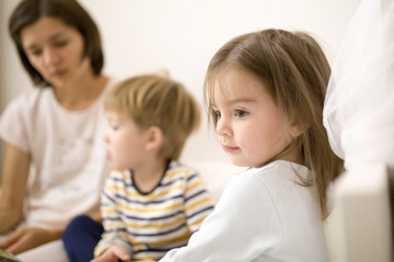 Mom with children reads a book before going to bed