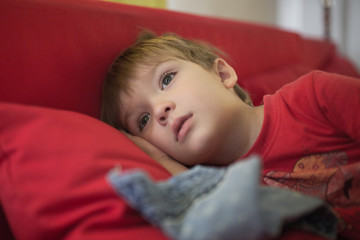 Little boy lies on a pillow with a handkerchief