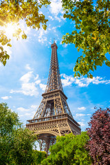 Der Eiffelturm in Paris an einem wunderschönen Sommertag mit strahlender Sonne und umrahmt von...