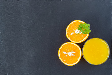 Glass of orange and orange juice cut in half