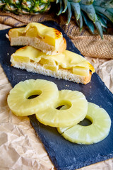A pineapple and cheese sandwich on a slate plate.