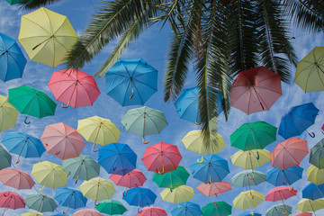 Fototapeta na wymiar umbrella of different colors floating in the sky, copy-space