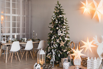 Christmas decorated Kitchen and living room interior in scandinavian style with christmas tree. Cozy home moment. Concept Happy New Year. Real photo. 