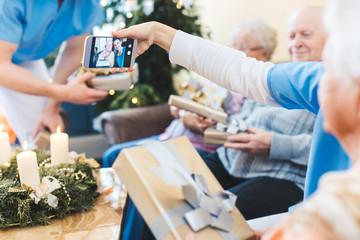 Seniors and nurses taking Christmas pictures in nursing home