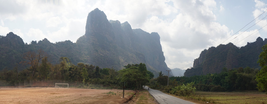 Buddha Statues in a green field at the base of Mount Zwegabin near Hpa-An, Myanmar.