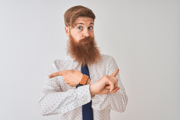 Young redhead irish businessman standing over isolated white background Pointing to both sides with fingers, different direction disagree